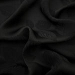 Black botanical leaf print viscose fabric with fluid garment drape