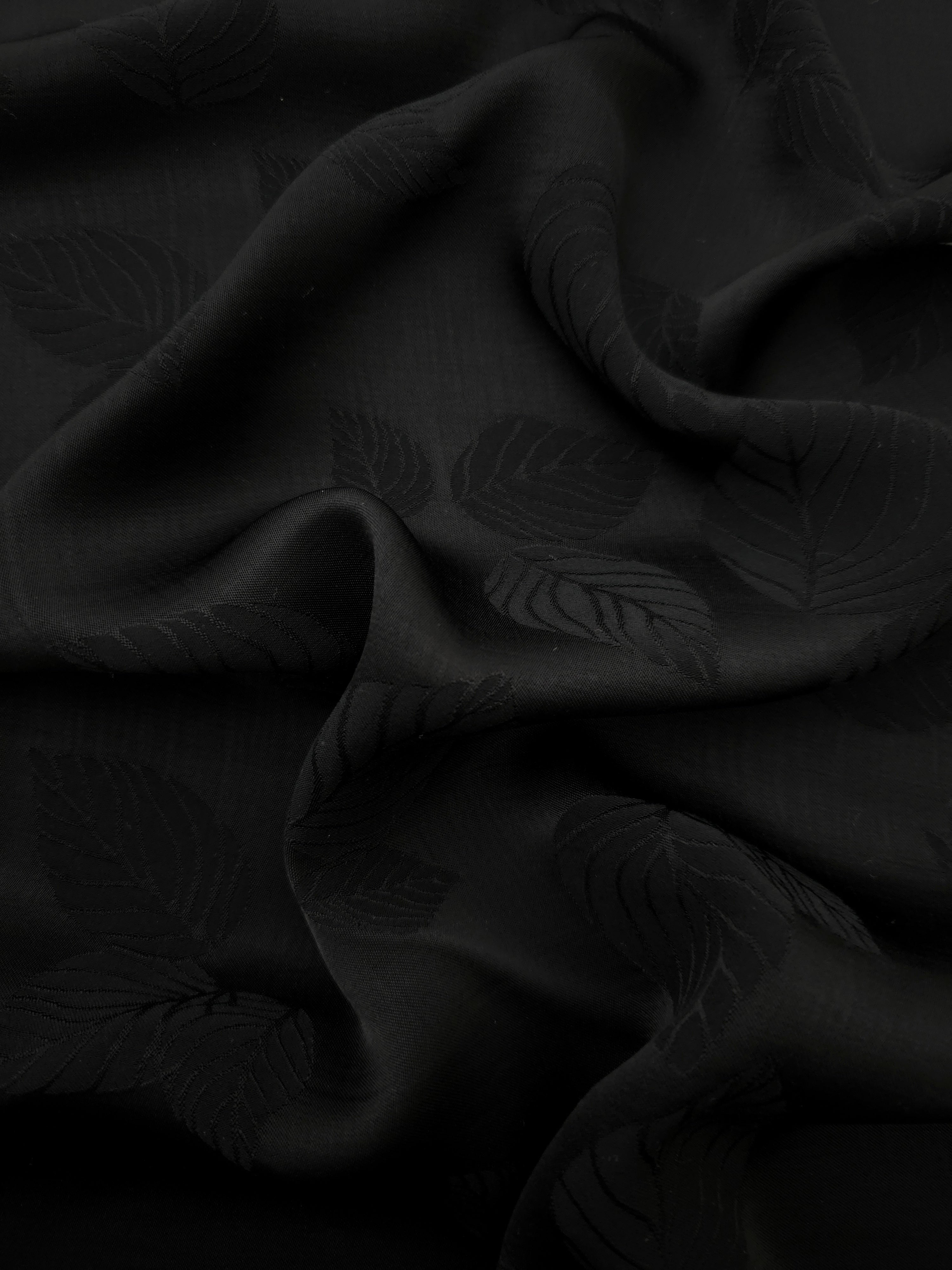 Black botanical leaf print viscose fabric with fluid garment drape