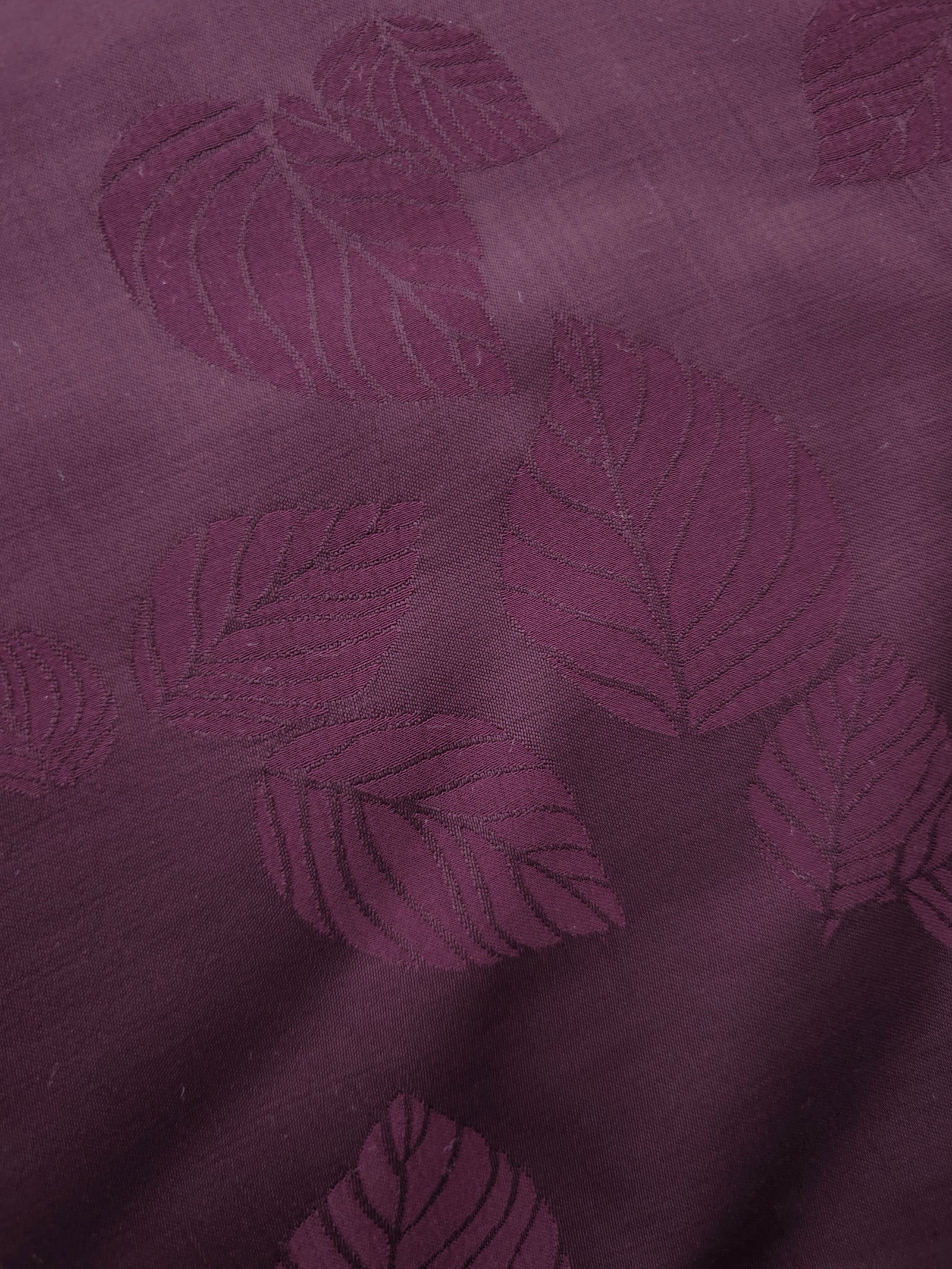 Close-up of cherry burgundy botanical leaf print viscose fabric