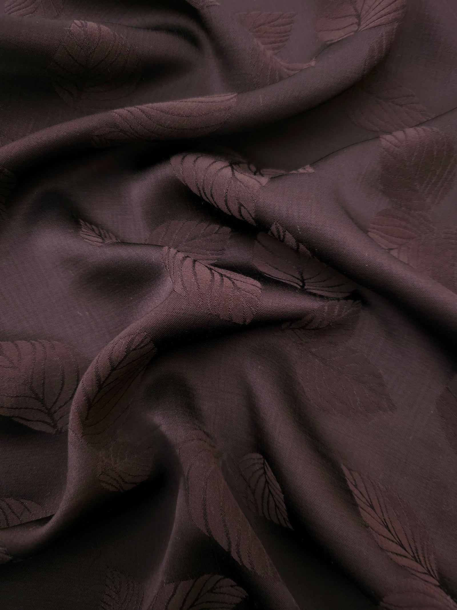 Warm beige botanical leaf print viscose fabric with flowing drape