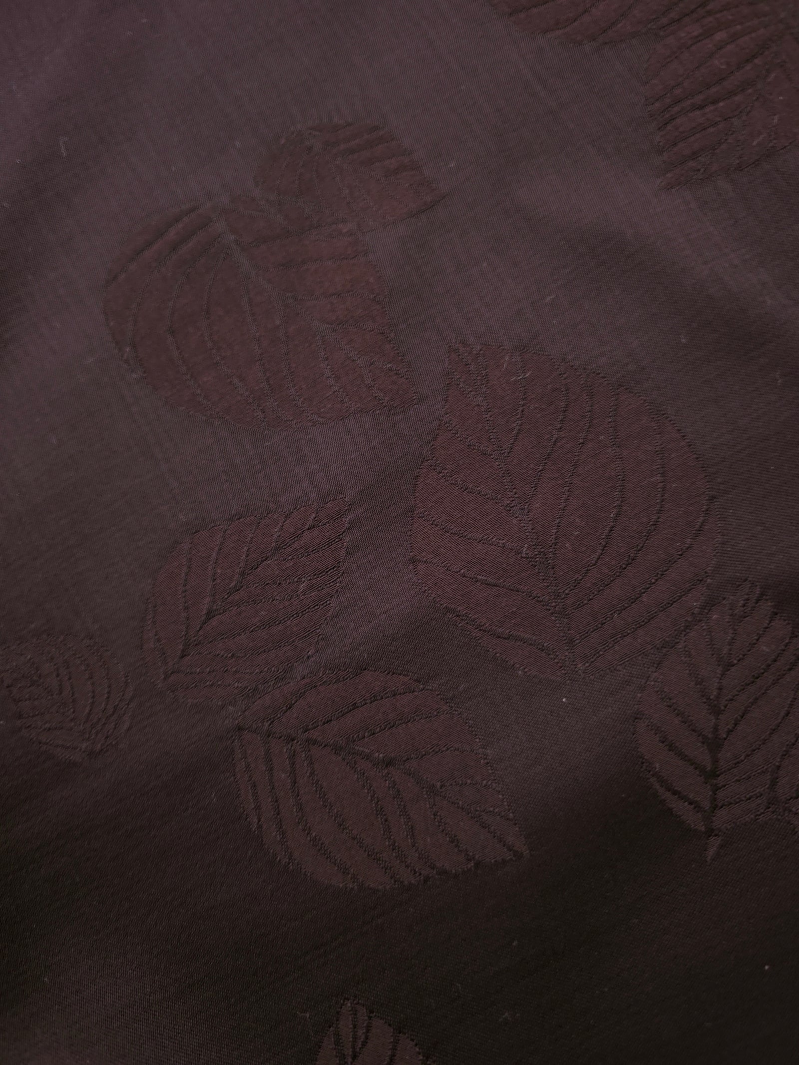 Close-up of warm beige botanical leaf print viscose fabric