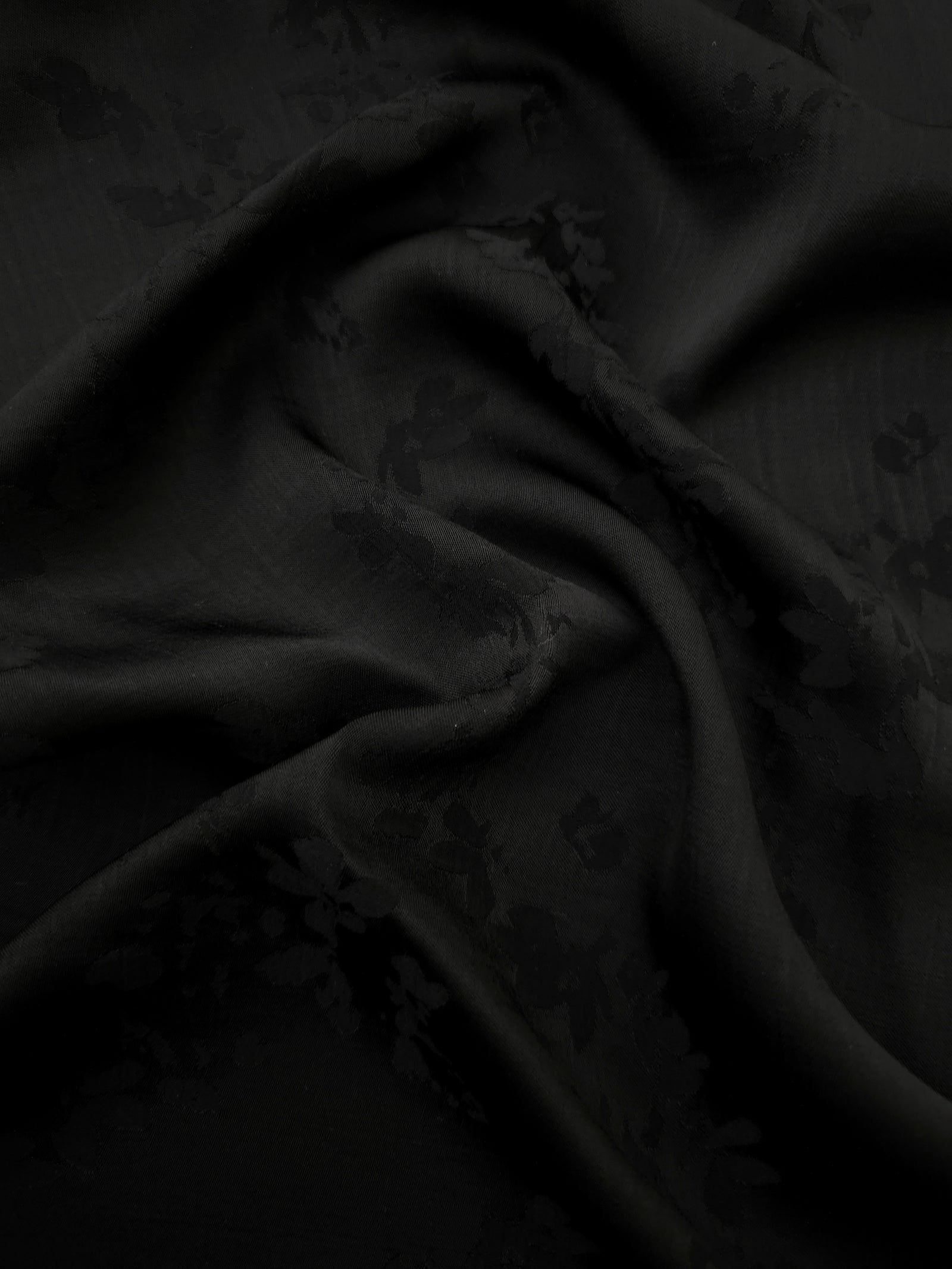 Black petal flower print viscose fabric with fluid garment drape