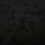 Close-up of black petal flower print on soft 100% viscose fabric