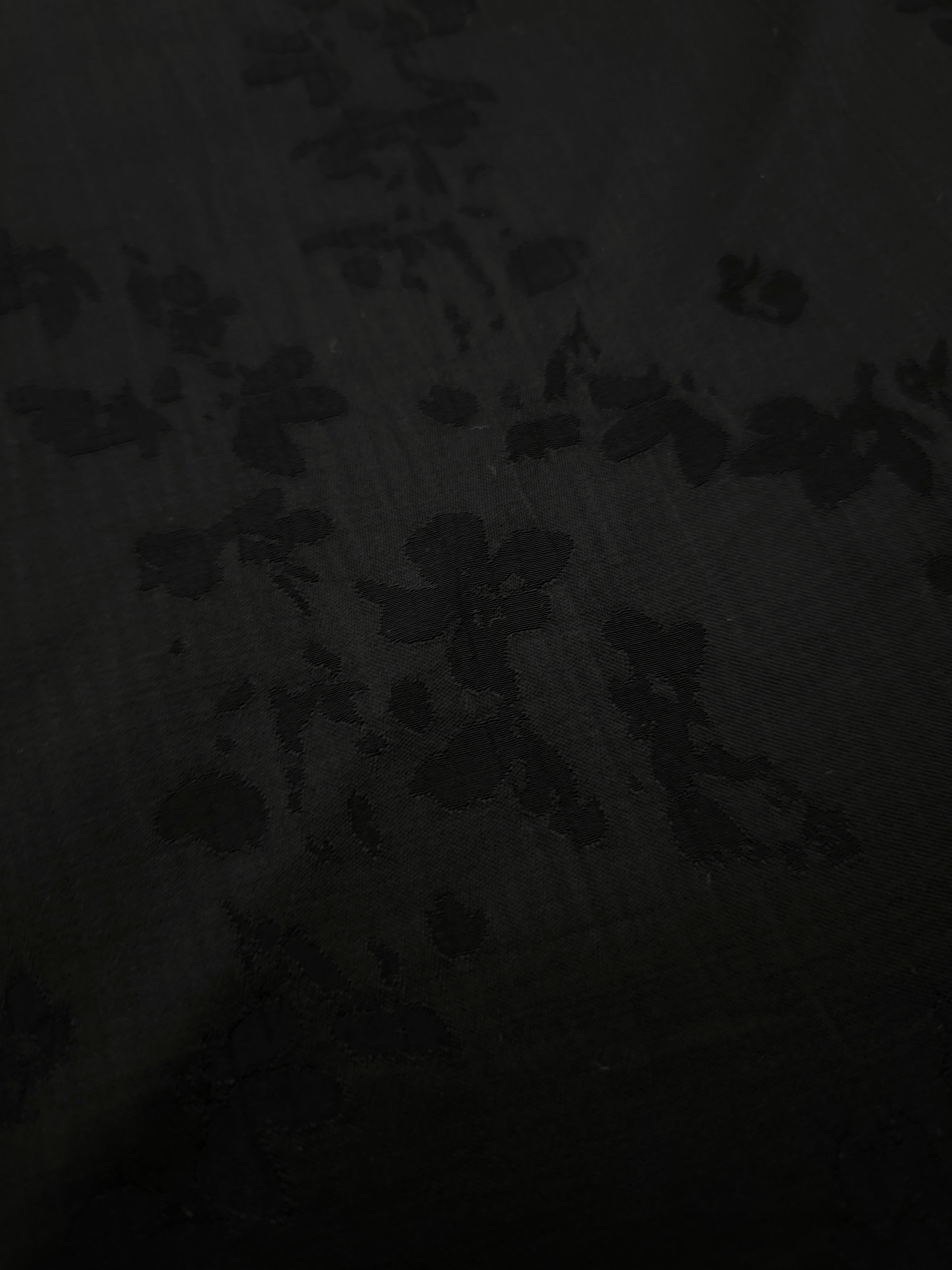 Close-up of black petal flower print on soft 100% viscose fabric