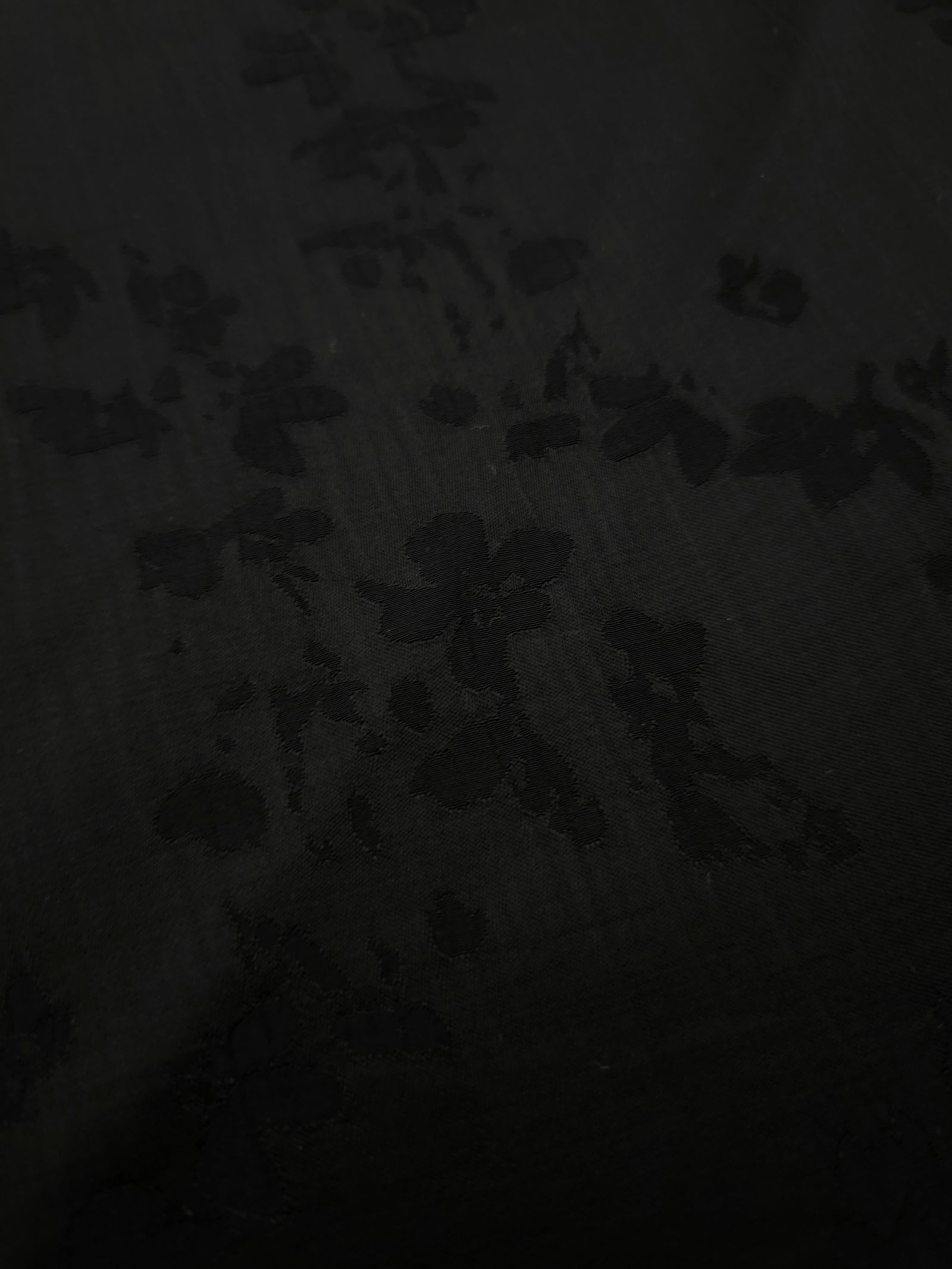 Close-up of black petal flower print on soft 100% viscose fabric