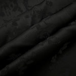 Detailed black petal flower print viscose fabric showing floral motif