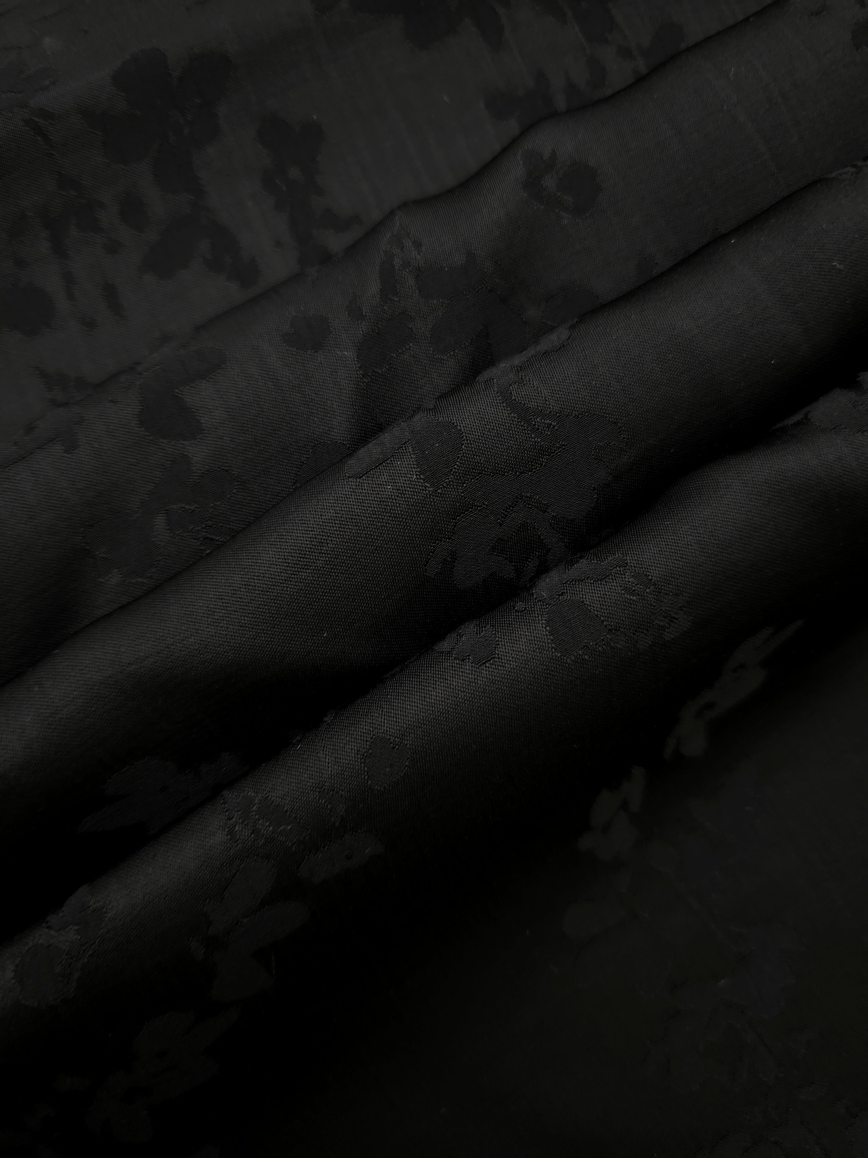 Detailed black petal flower print viscose fabric showing floral motif