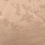 Close-up of warm beige petal flower print viscose fabric