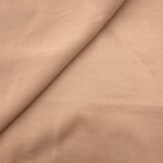 Close-up of warm beige plain viscose fabric showing natural woven texture
