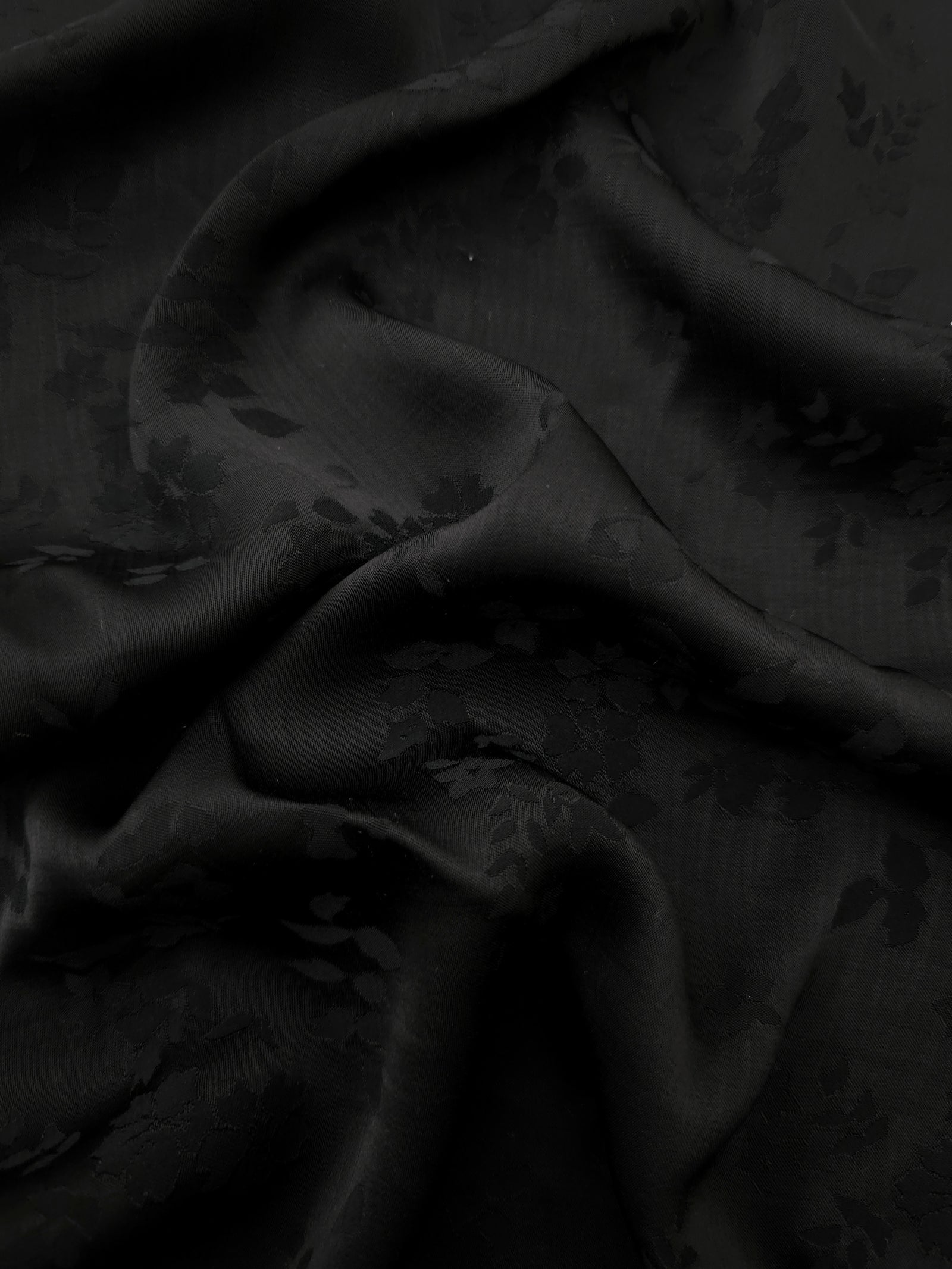 Black stylized leaf print viscose fabric with fluid garment drape