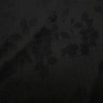 Close-up of black stylized leaf print on soft 100% viscose fabric