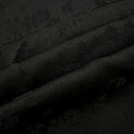 Detailed black stylized leaf print viscose fabric showing modern motif