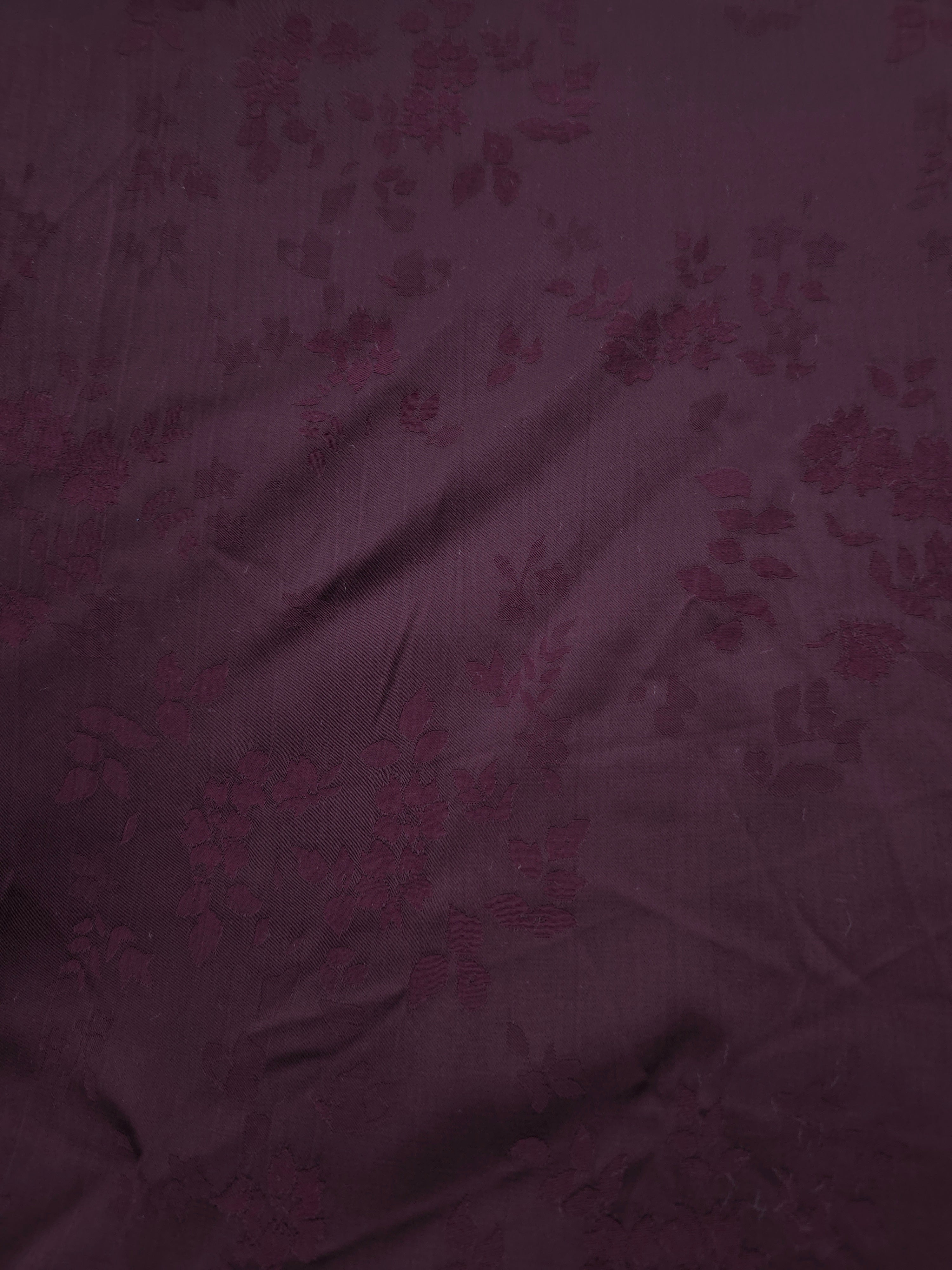 Close-up of cherry burgundy stylized leaf print viscose fabric