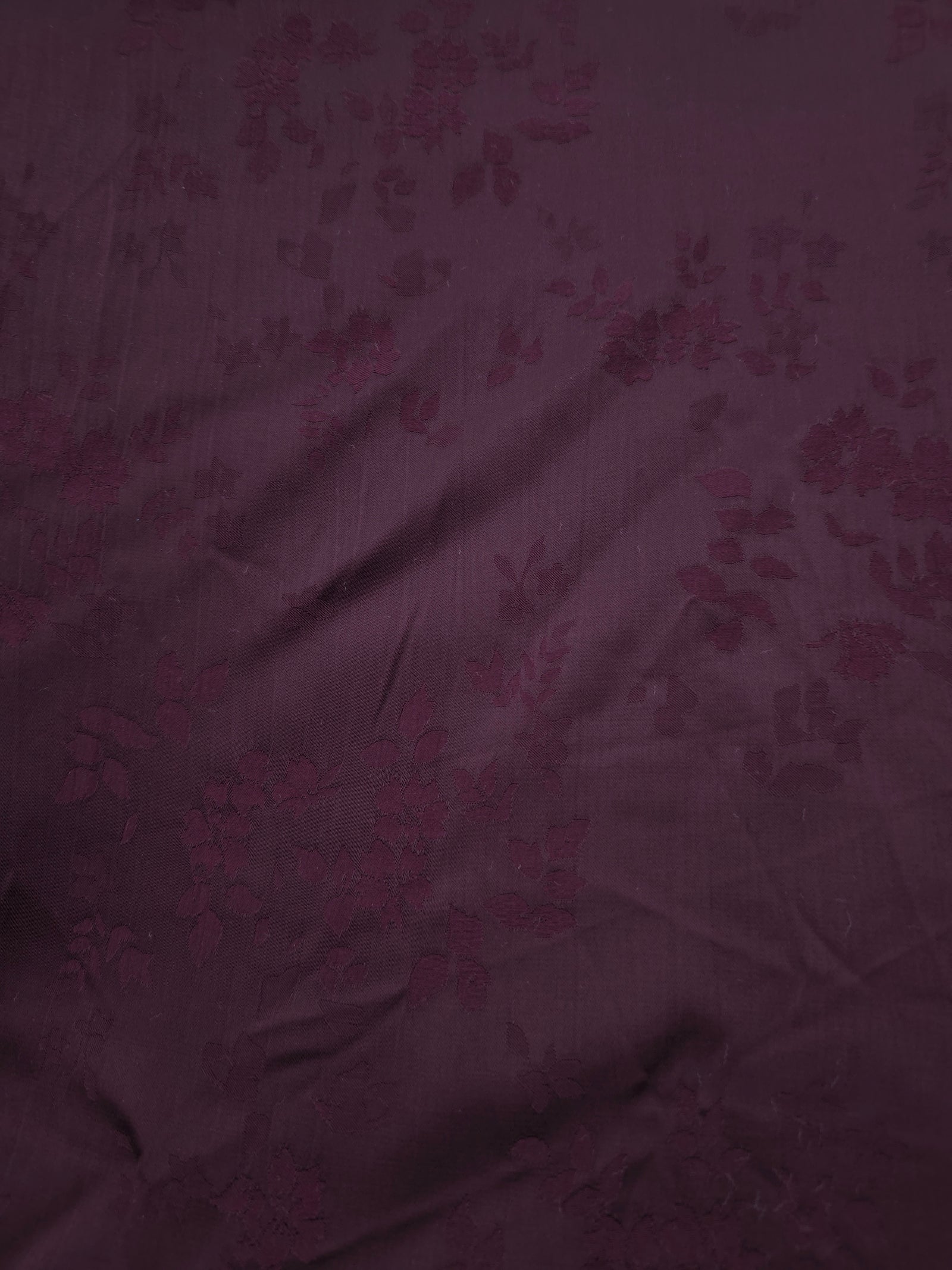 Close-up of cherry burgundy stylized leaf print viscose fabric