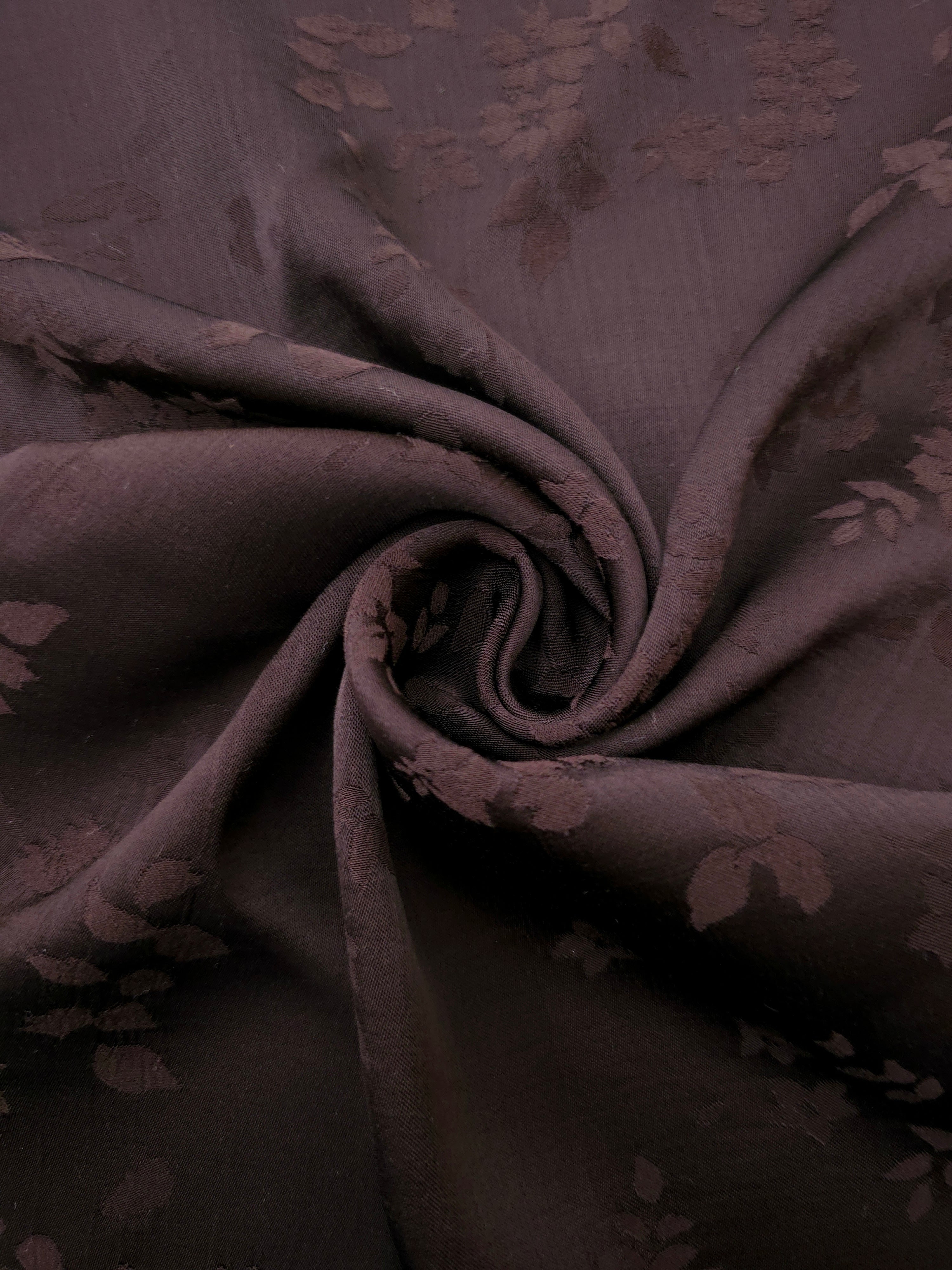Close-up of warm beige stylized leaf print viscose fabric