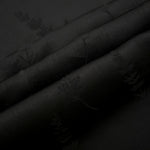 Detailed black wild tree print viscose fabric showing botanical motif