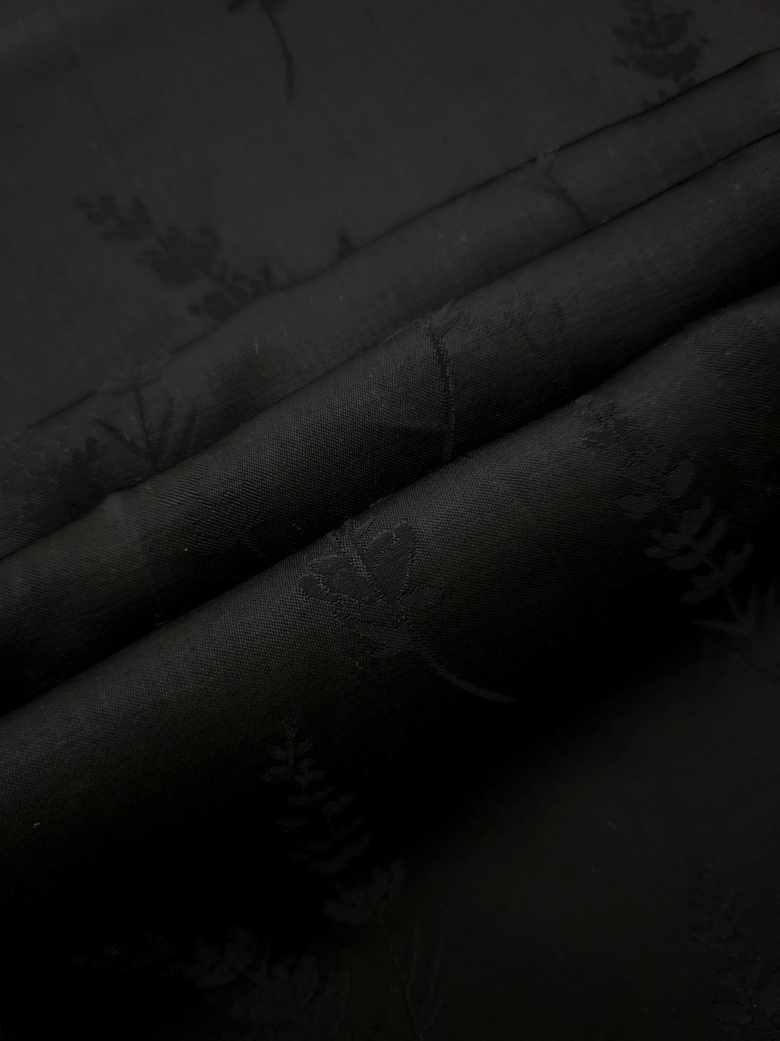 Detailed black wild tree print viscose fabric showing botanical motif