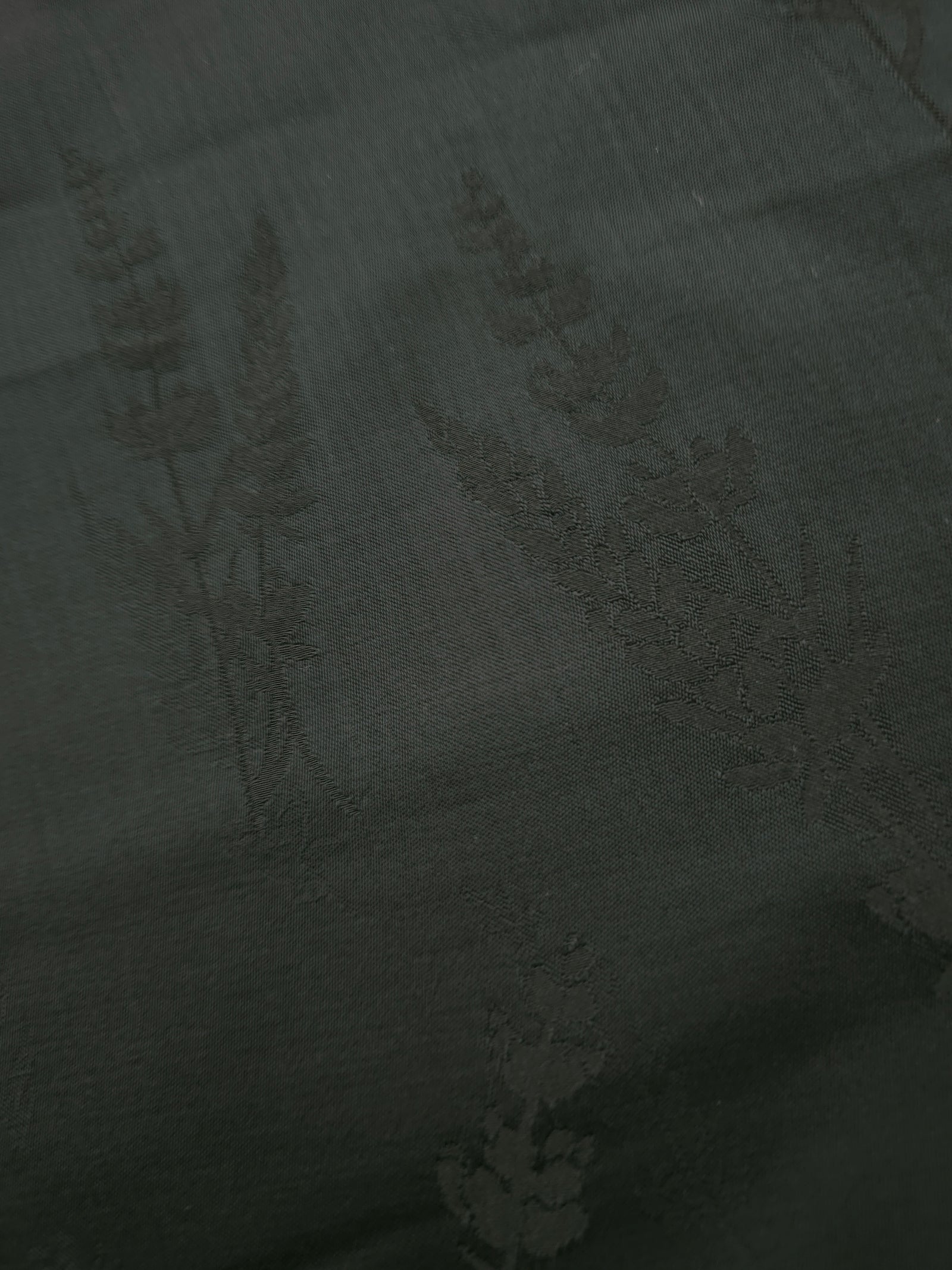 Close-up of dark green wild tree botanical print viscose fabric