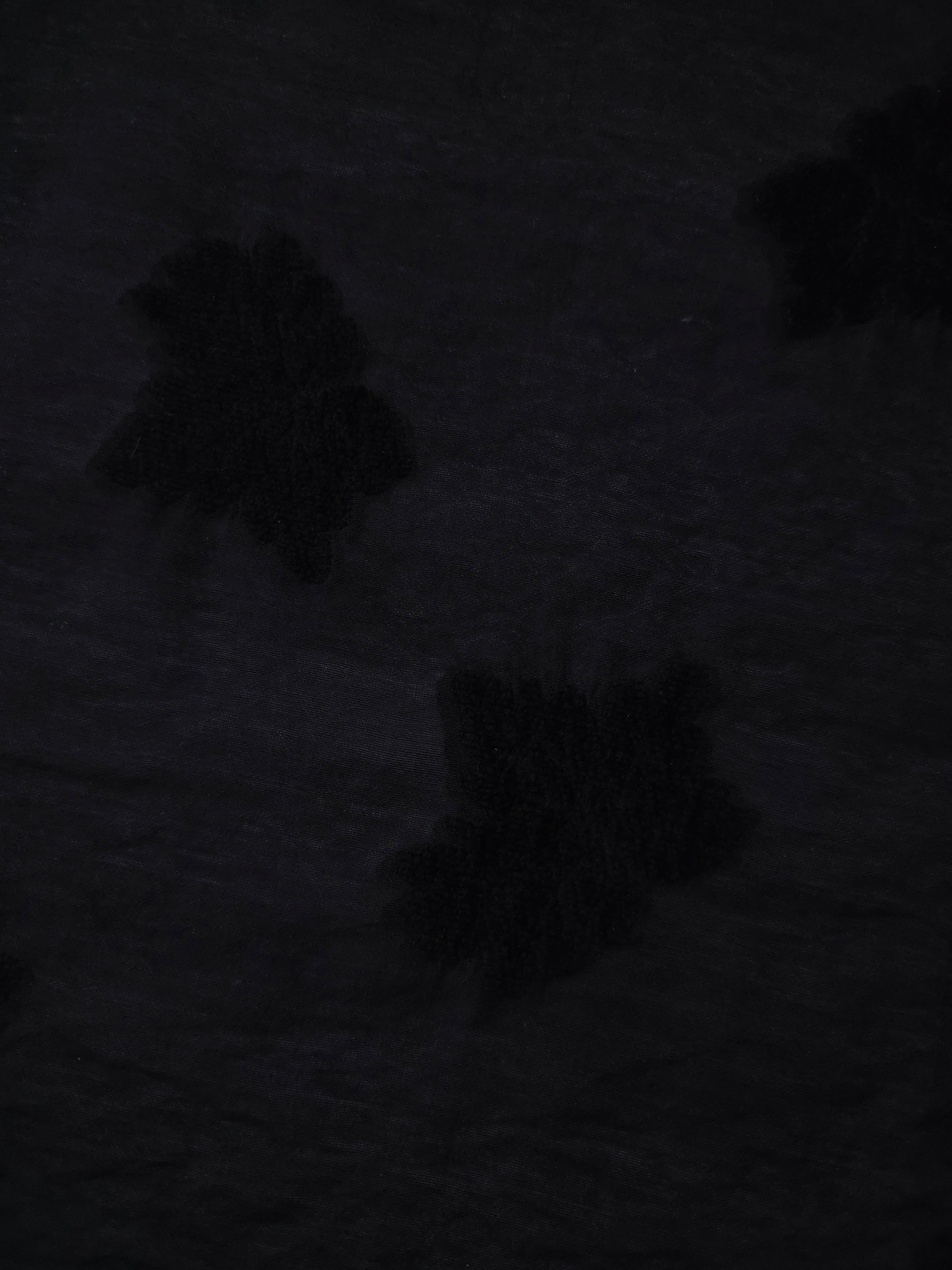 Closeup texture of formal black big leaf embossed viscose jacquard fabric.