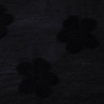 Closeup texture of formal black flower embossed viscose jacquard fabric.