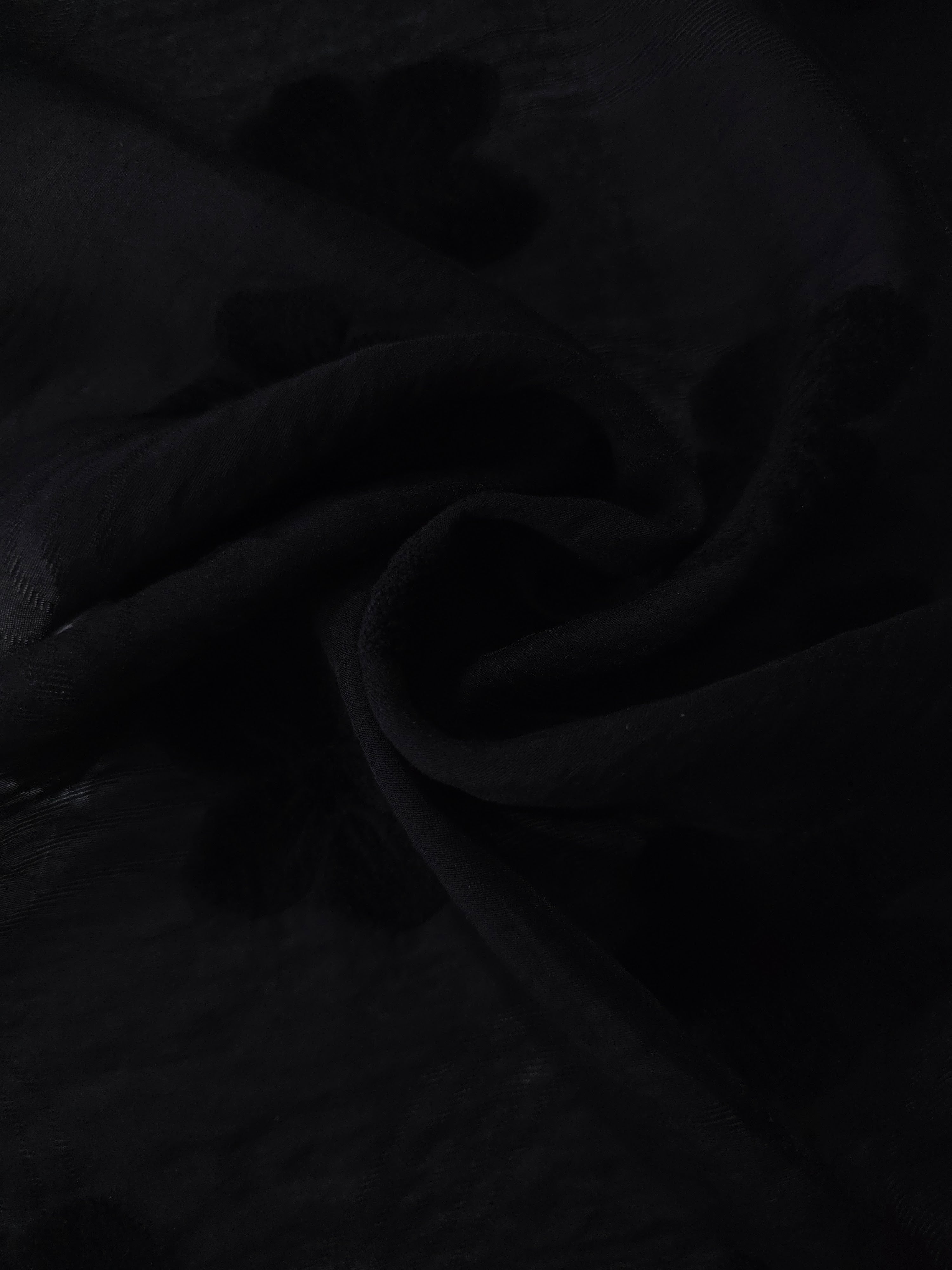 Draped texture of formal black flower embossed viscose jacquard fabric for garment layers.
