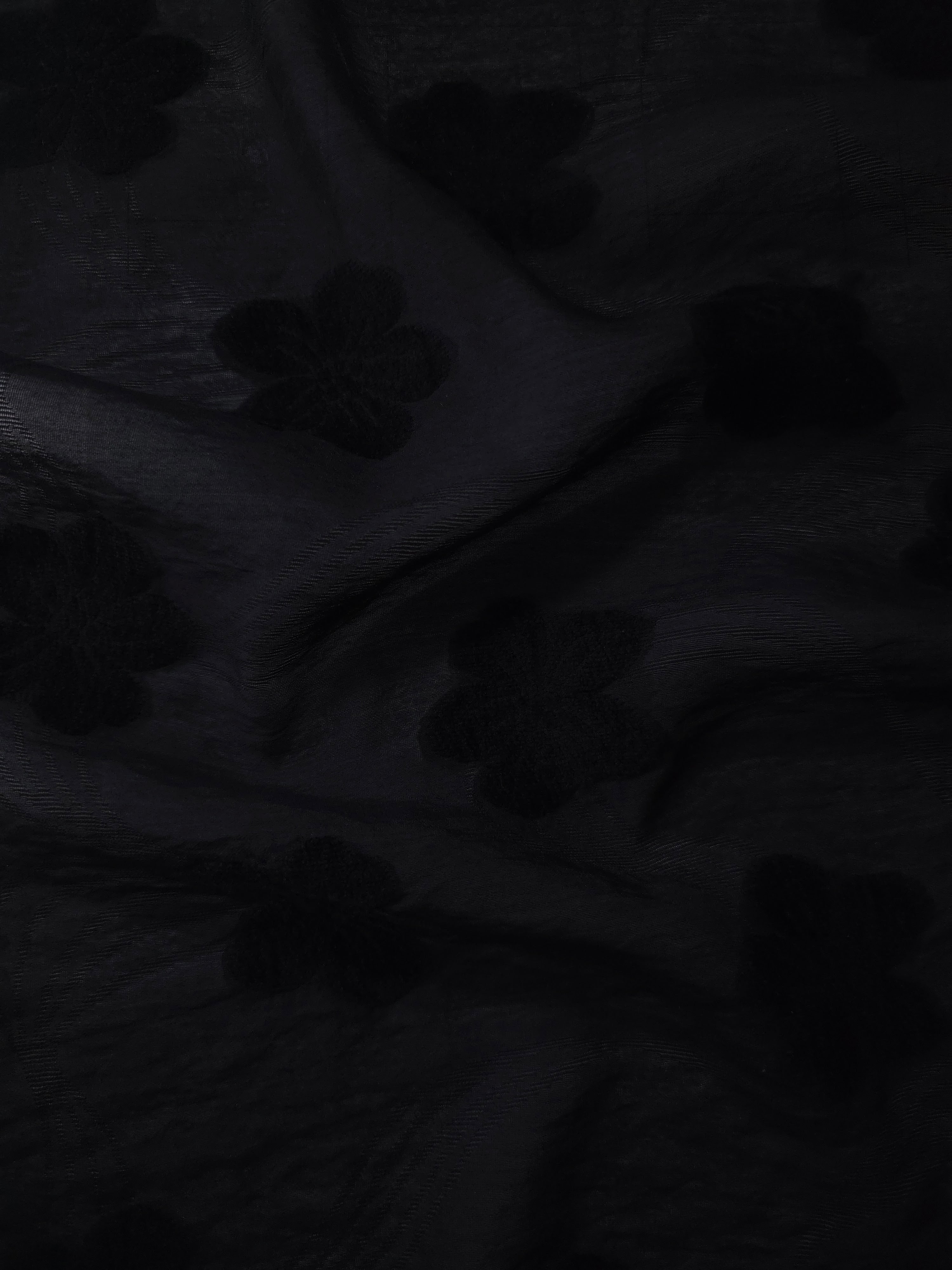 Drape view of formal black flower embossed viscose jacquard fabric for kaftan overlays.
