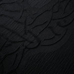 Pattern detail of black laurel polyester crepe jacquard fabric with raised woven texture.