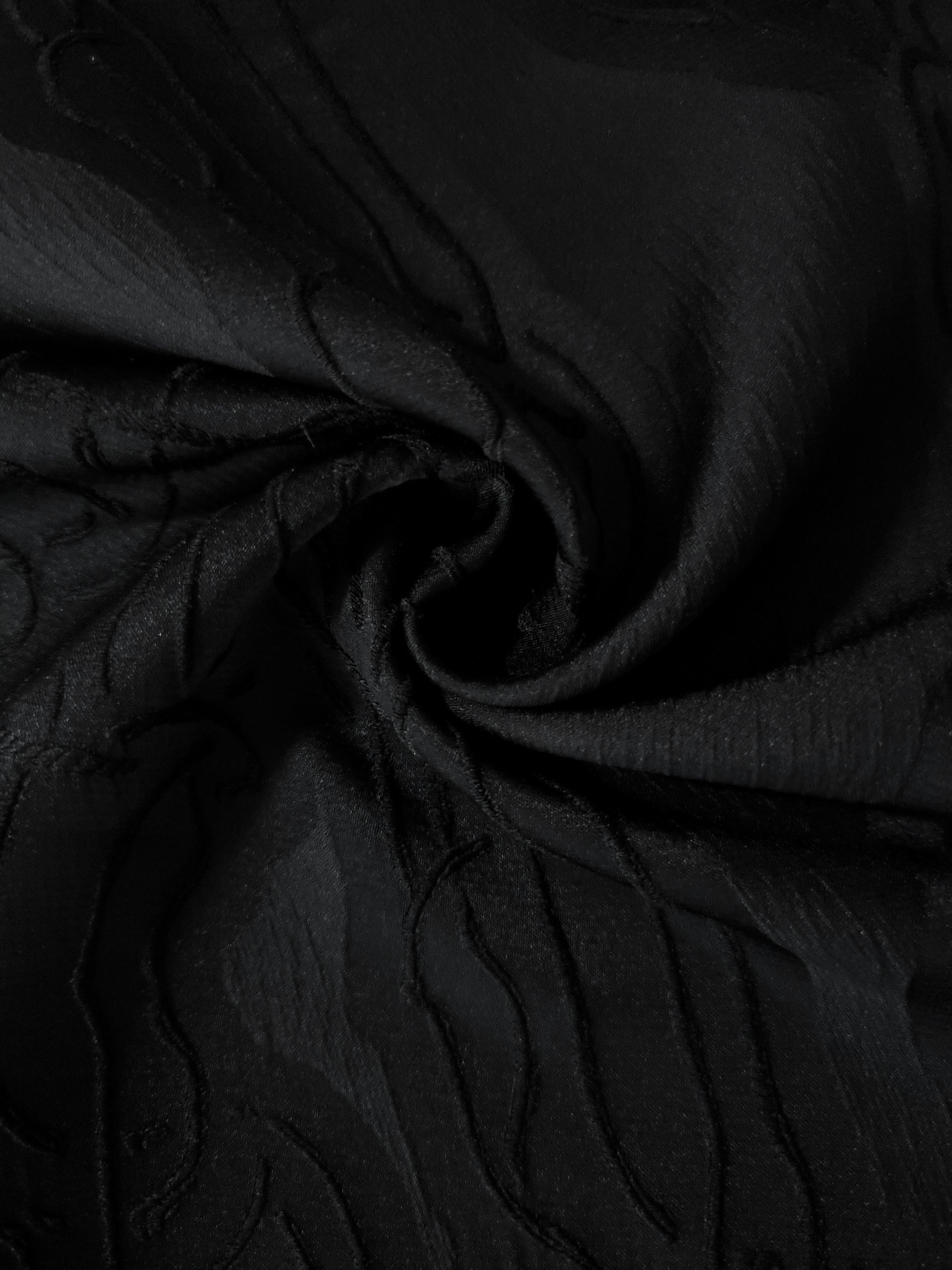 Drape view of black laurel polyester crepe jacquard fabric for dresses, skirts and jackets.