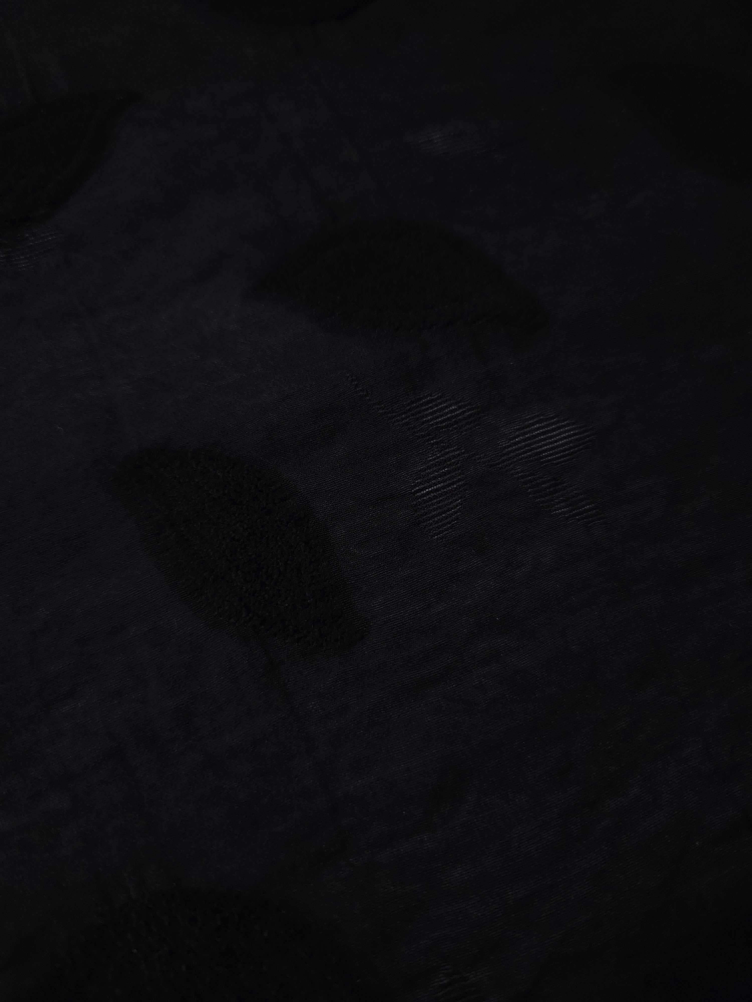 Closeup texture of formal black leaf embossed viscose jacquard fabric.
