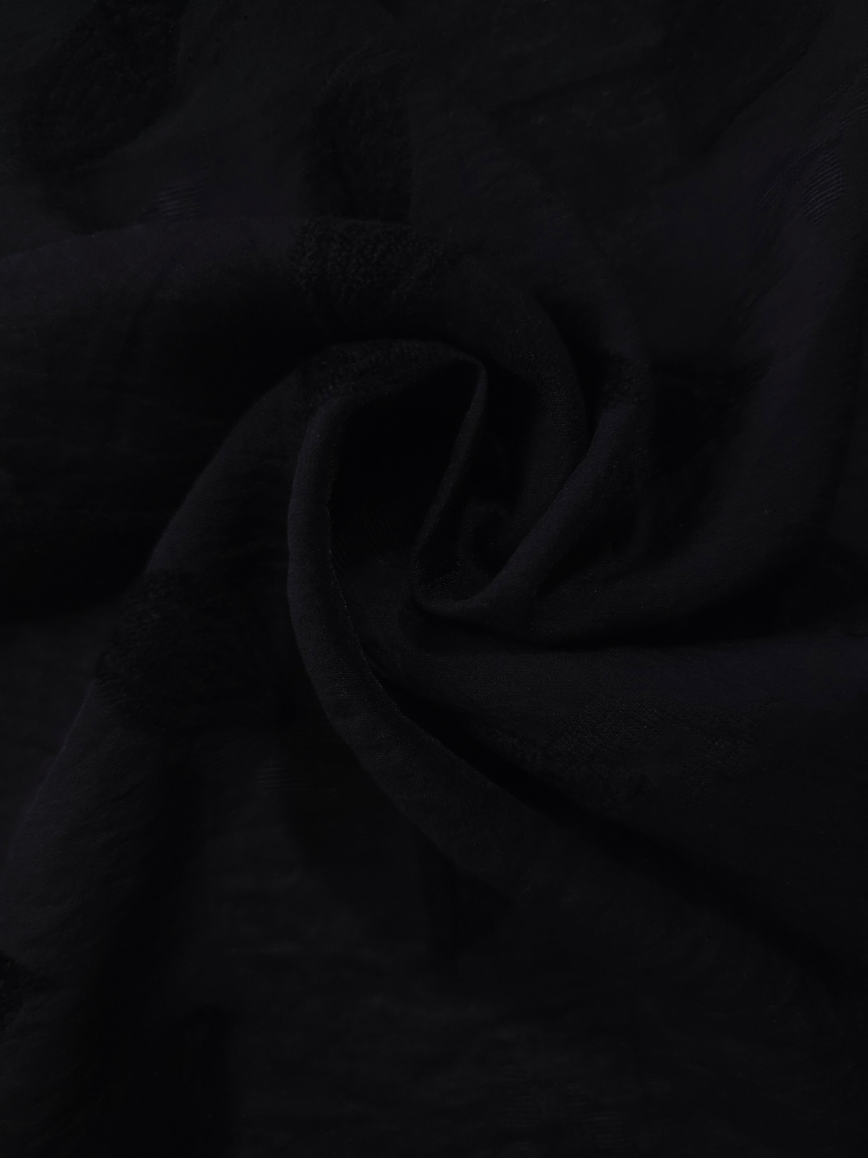 Draped texture of formal black leaf embossed viscose jacquard fabric for garment layers.