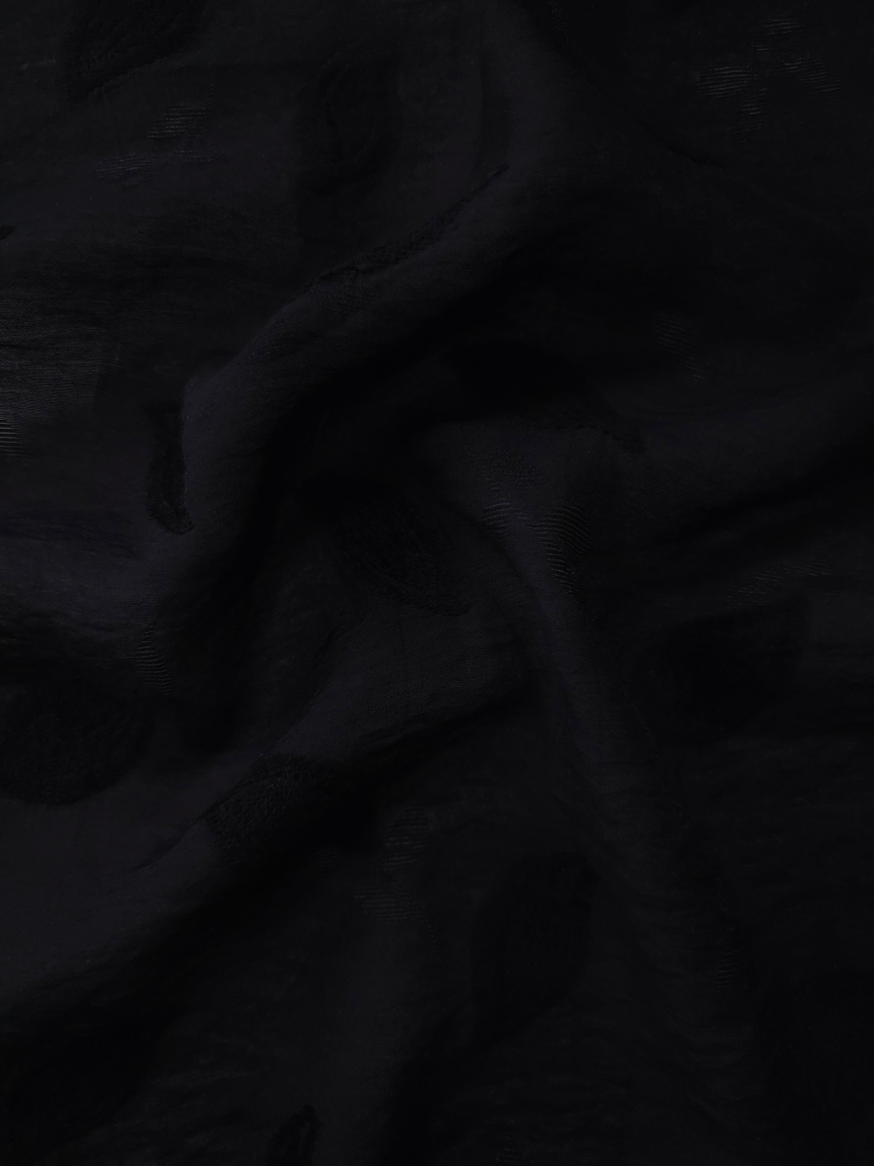 Drape view of formal black leaf embossed viscose jacquard fabric for kaftan overlays.