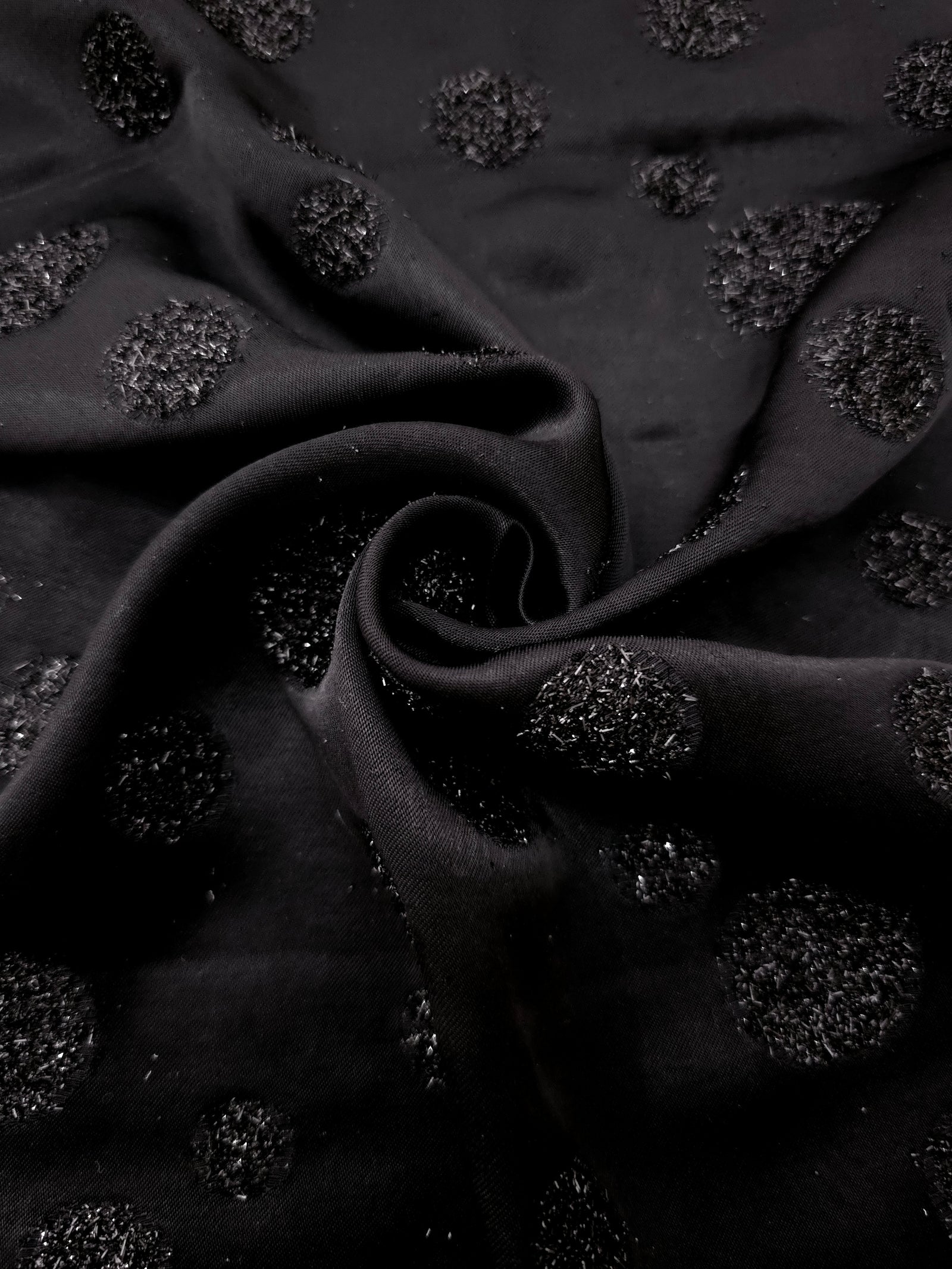 Folded Metallic Black viscose jacquard fabric featuring scattered metallic confetti dots