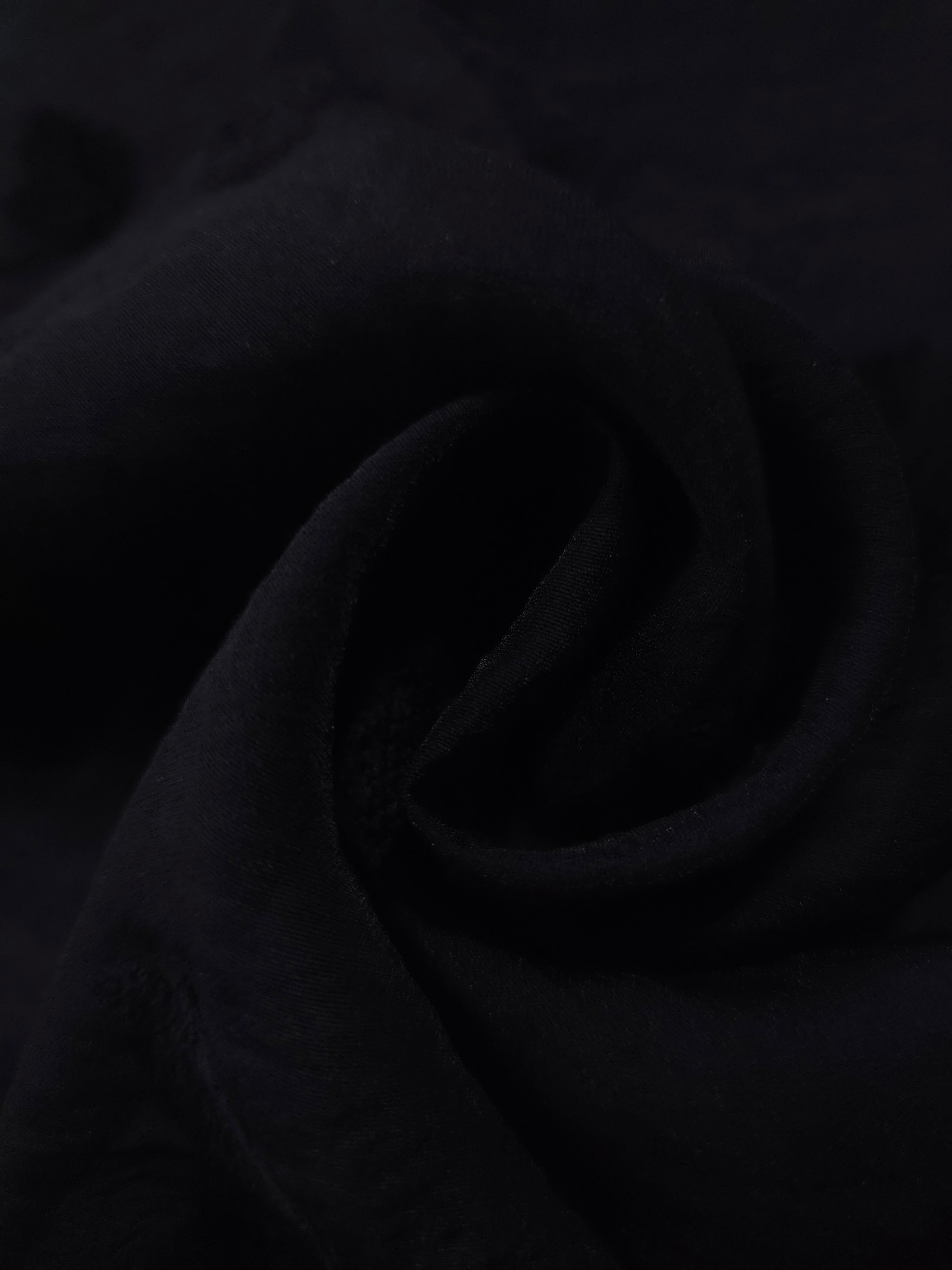 Formal black small leaf embossed viscose jacquard fabric closeup for sheer overlays.