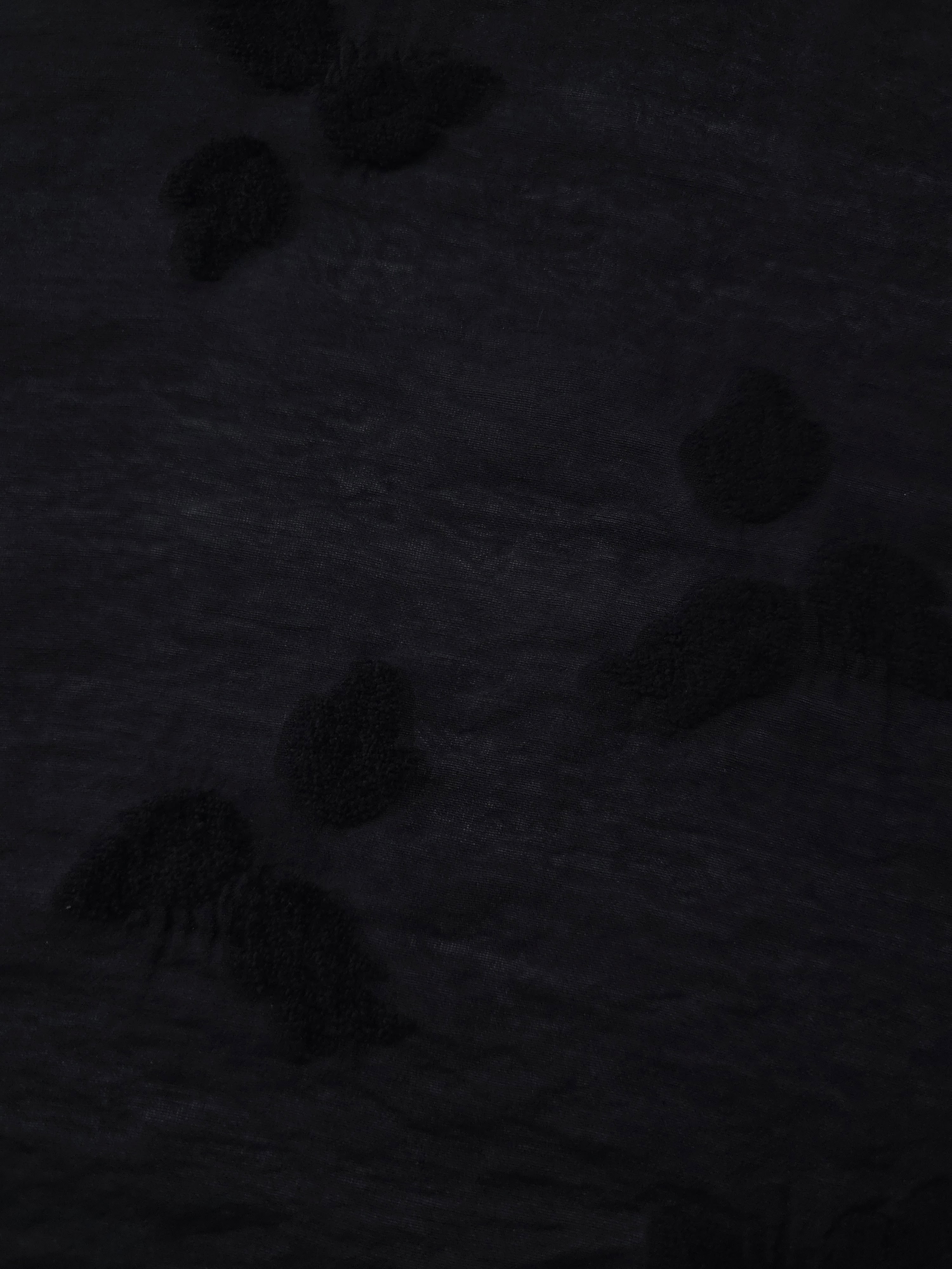 Closeup texture of formal black small leaf embossed viscose jacquard fabric.