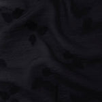Drape view of formal black small leaf embossed viscose jacquard fabric for garment layers.
