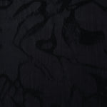 Black abstract scroll lyocell viscose jacquard showing tonal woven pattern for dress fabric.