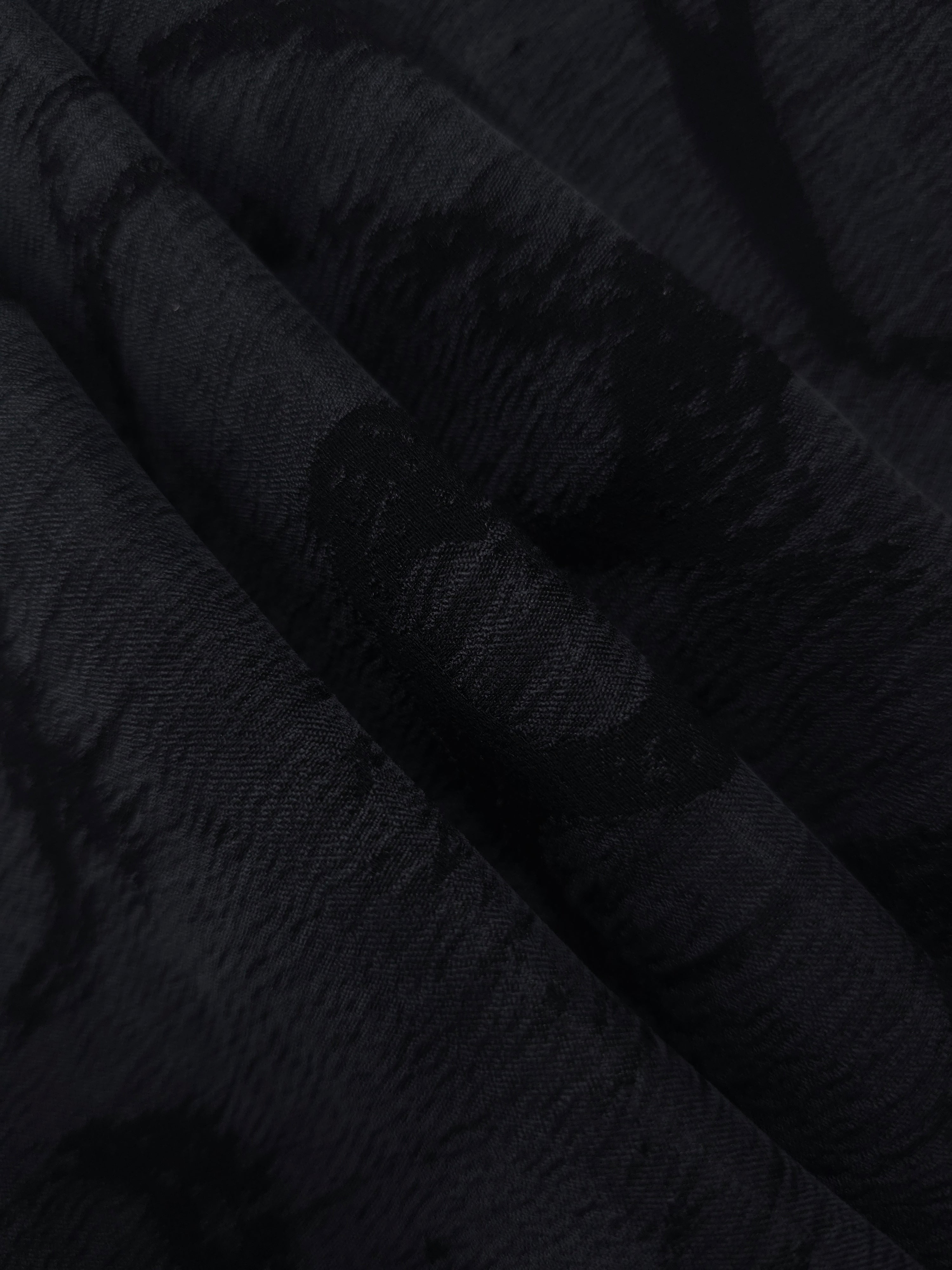 Folded black abstract scroll jacquard fabric for skirts, jackets and occasion pieces.