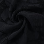 Swirl drape of black lyocell viscose jacquard with abstract scroll movement.