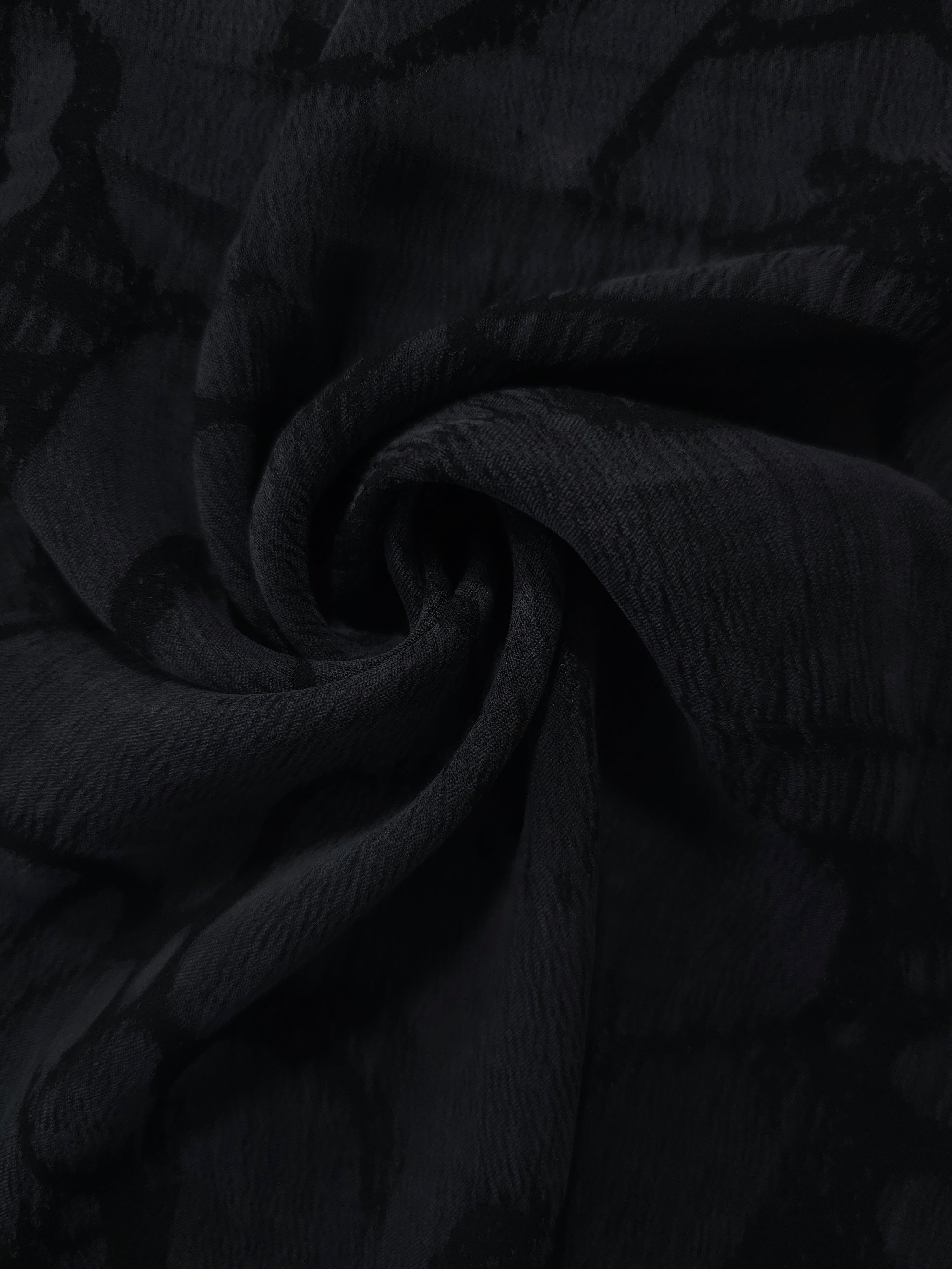 Swirl drape of black lyocell viscose jacquard with abstract scroll movement.