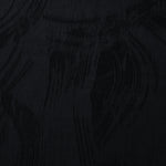 Close texture of black arc brushstroke jacquard showing smooth base and raised pattern.