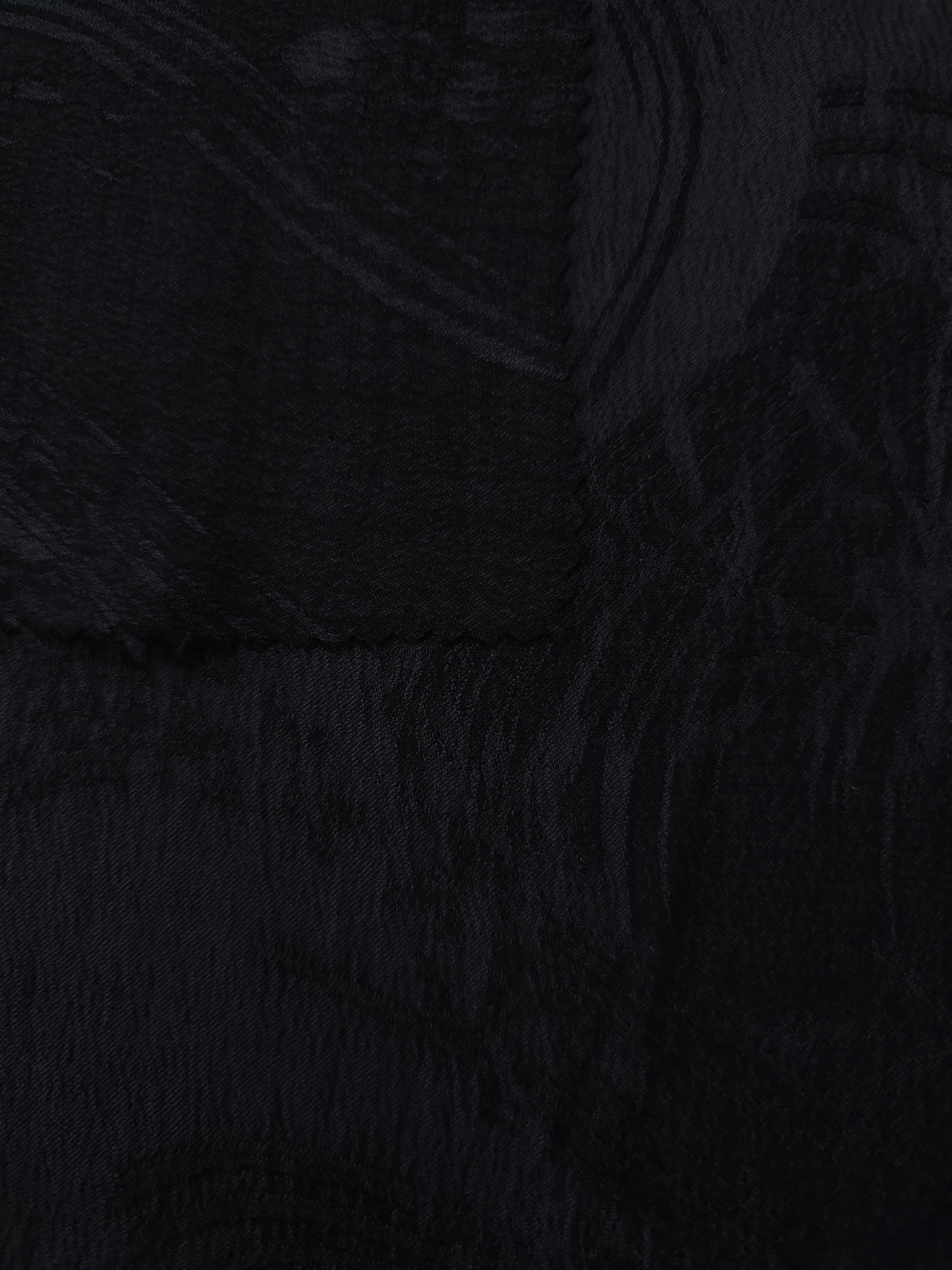 Selvage detail of black arc brushstroke lyocell viscose jacquard fabric.
