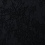 Close texture of black botanical floral jacquard showing raised floral detail.