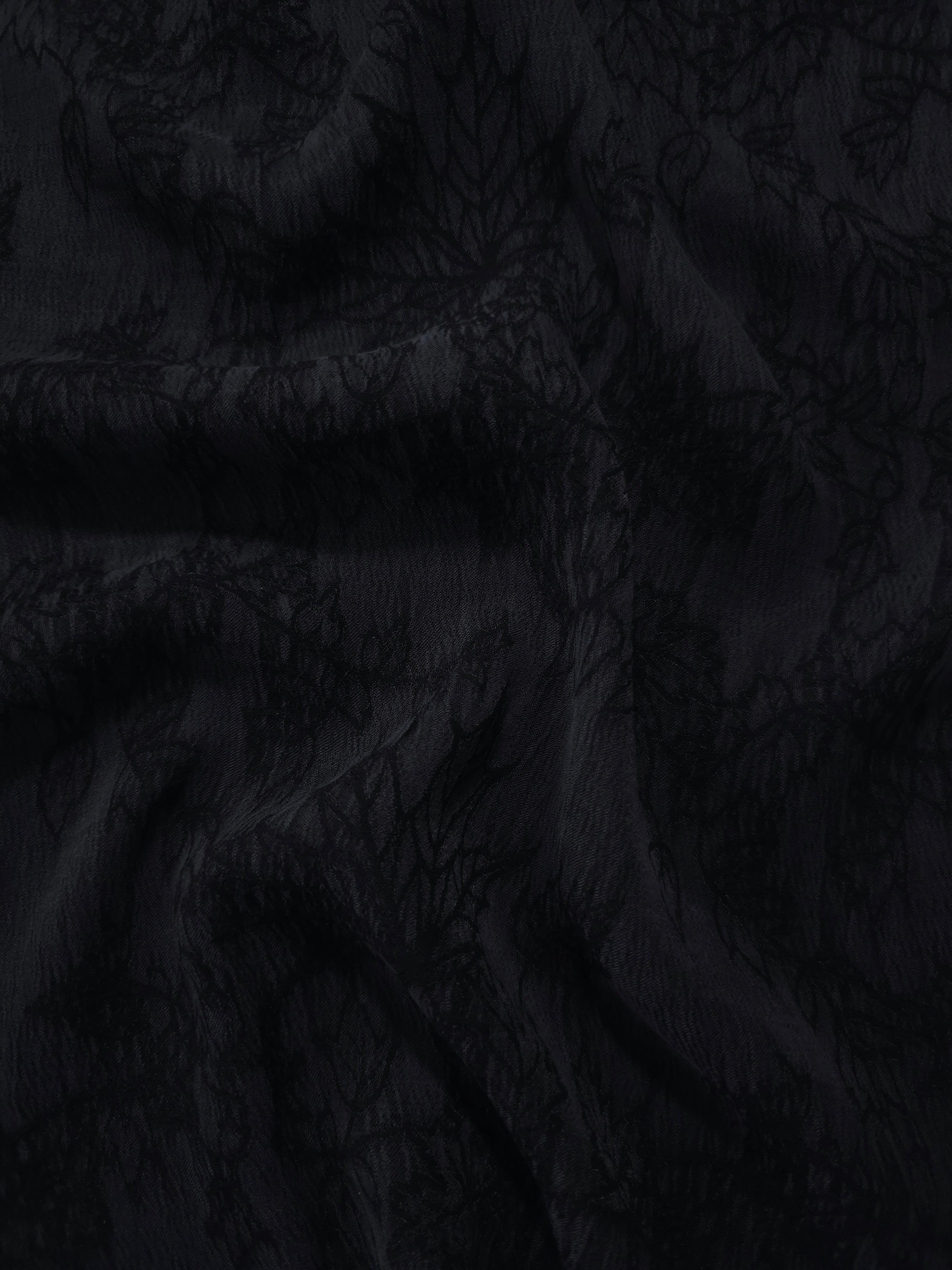 Draped black botanical floral jacquard showing textured flow for occasionwear.