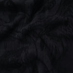 Draped black botanical scroll jacquard showing smooth flow for skirts and blouses.