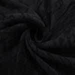 Swirl drape of black botanical scroll jacquard with darker tonal pattern.