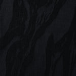 Close texture of black brushstroke leaf jacquard showing raised lyocell viscose weave.