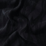 Draped black brushstroke leaf jacquard showing soft structure for jackets and skirts.