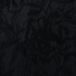 Close texture of black floral vine jacquard showing darker raised pattern on smooth base.