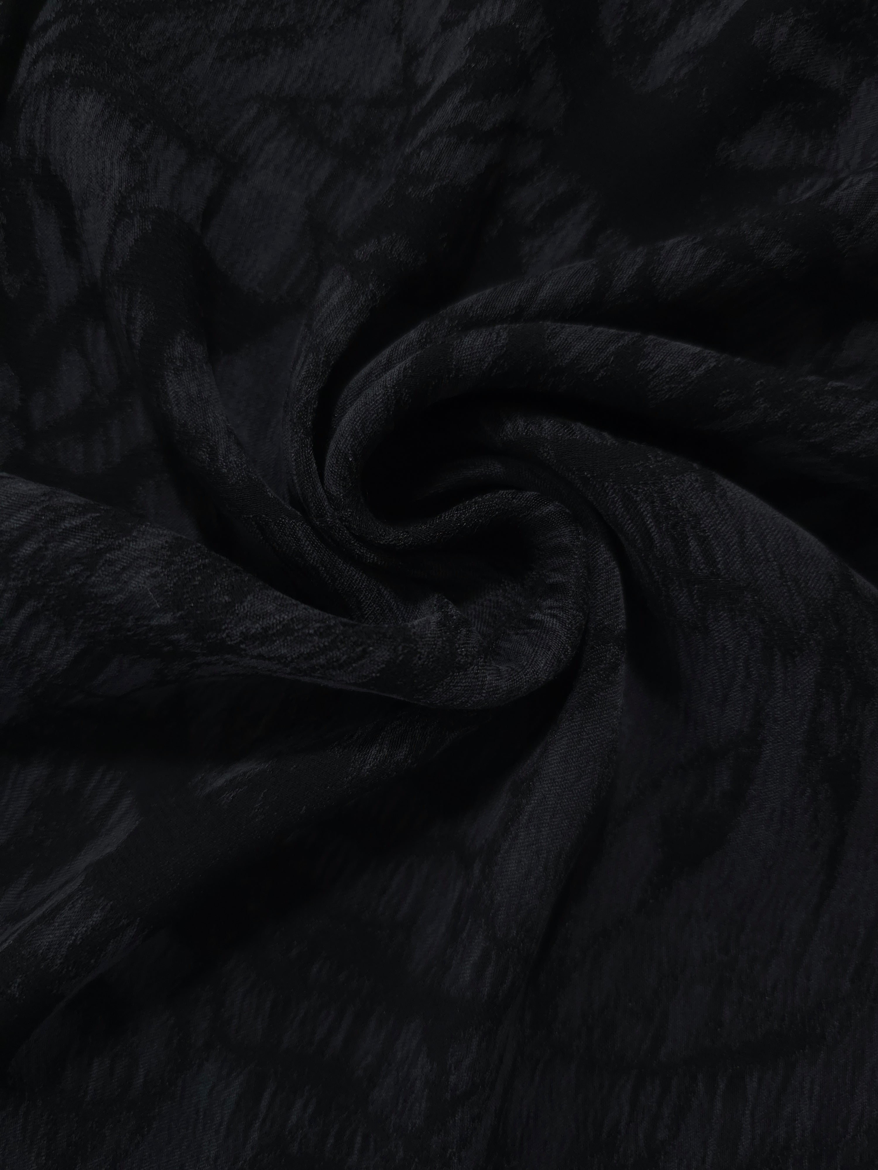 Folded black dense floral jacquard in lyocell viscose for evening and occasion sewing.
