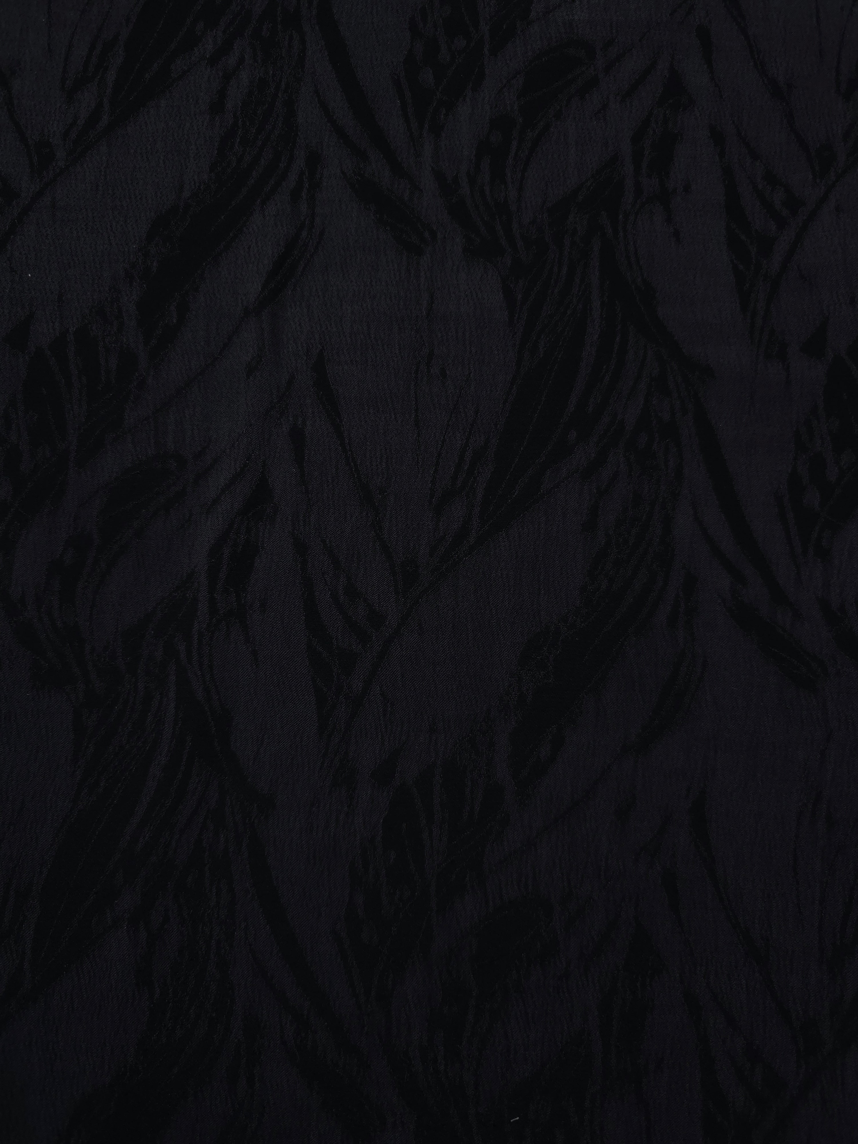 Close texture of black large leaf jacquard showing raised lyocell viscose detail.